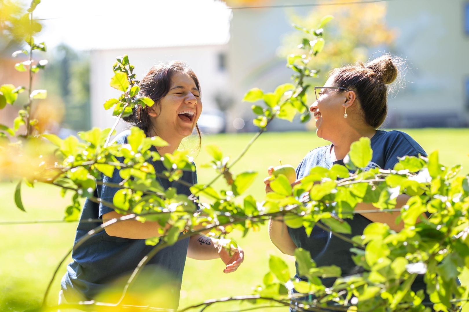 Pflegerinnen lachen und genießen einen sonnigen Arbeitstag im Freien
